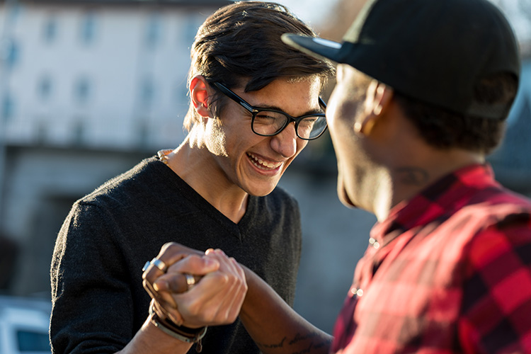 Two people smile and shake hands.