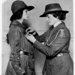 Girl Scouts of the USA founder Julliette Gordon Low, pinning a Girl Scout