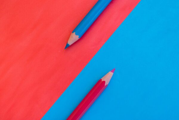Red colored pencil on blue background and blue colored pencil on red background
