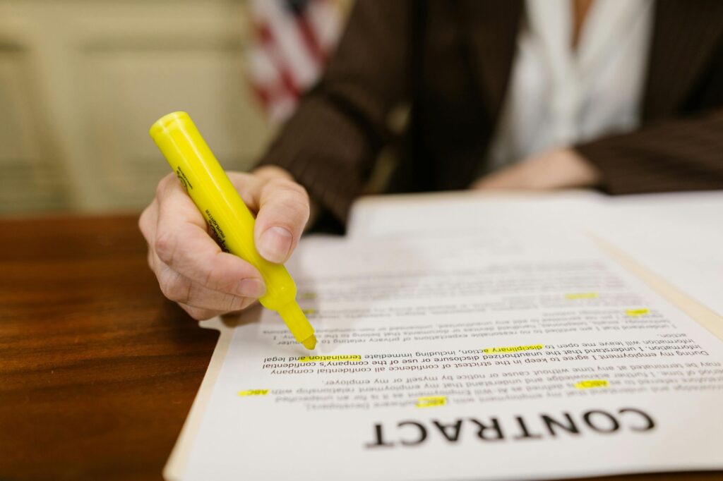 Business woman's hand marking up a contract with a highlighter