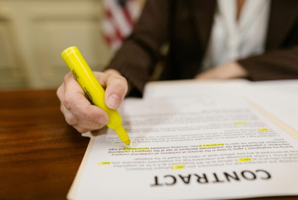 Business woman's hand marking up a contract with a highlighter